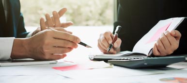 Understanding and planning for VoIP with hands, pencils and notebook.